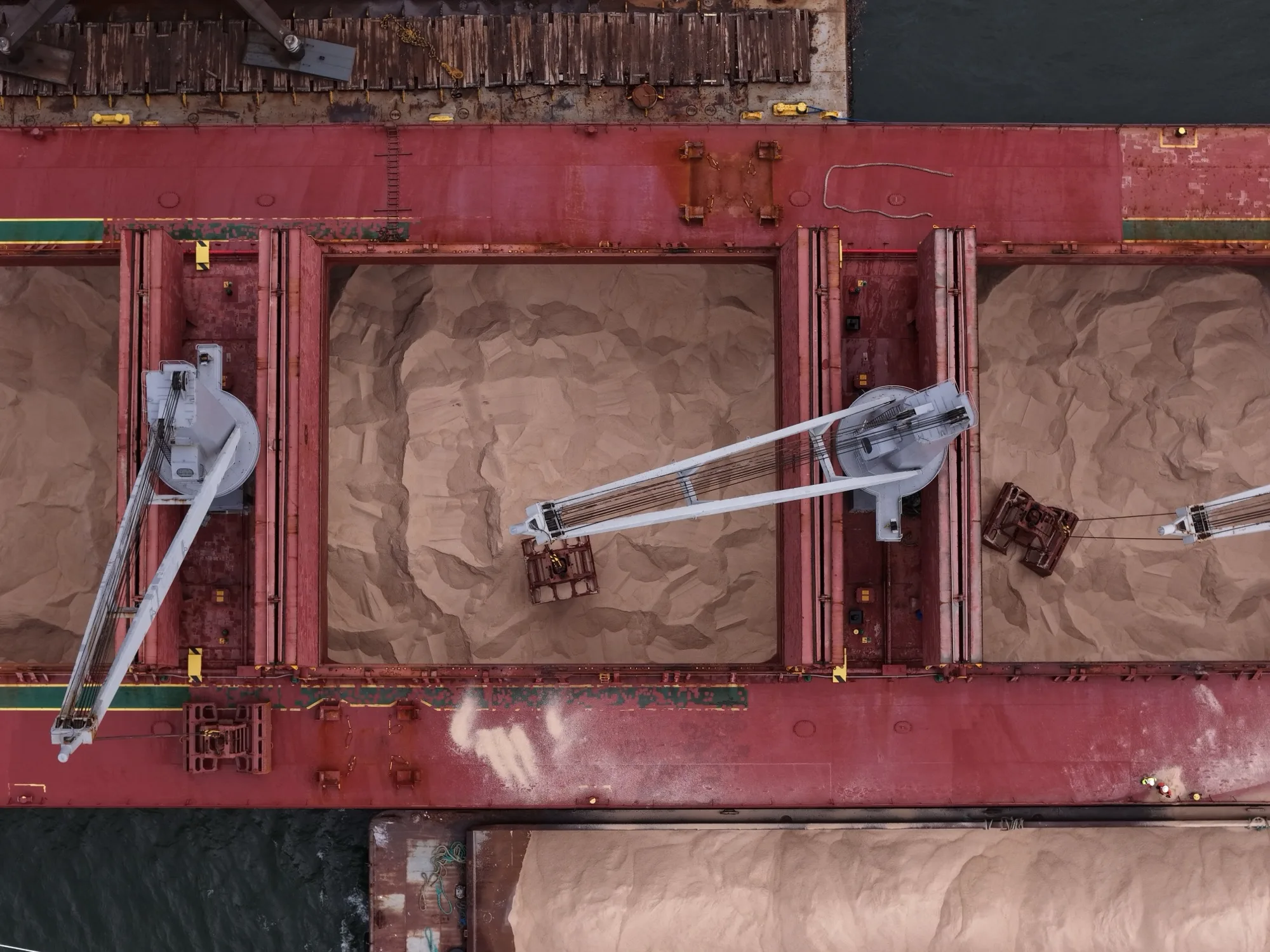 Looking straight down into the open holds of rock salt as the grabs work